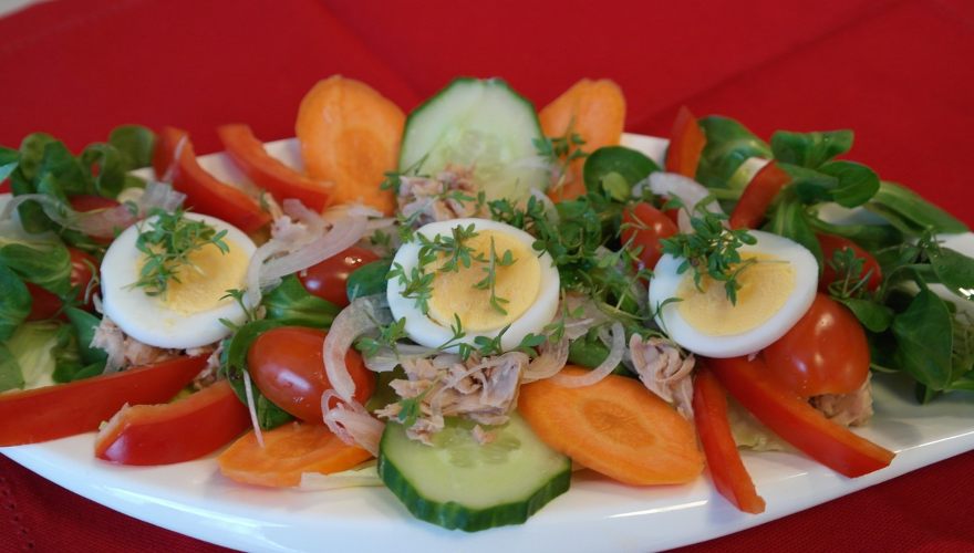 Salata sa tunom i povrćem i jajima u tanjiru.